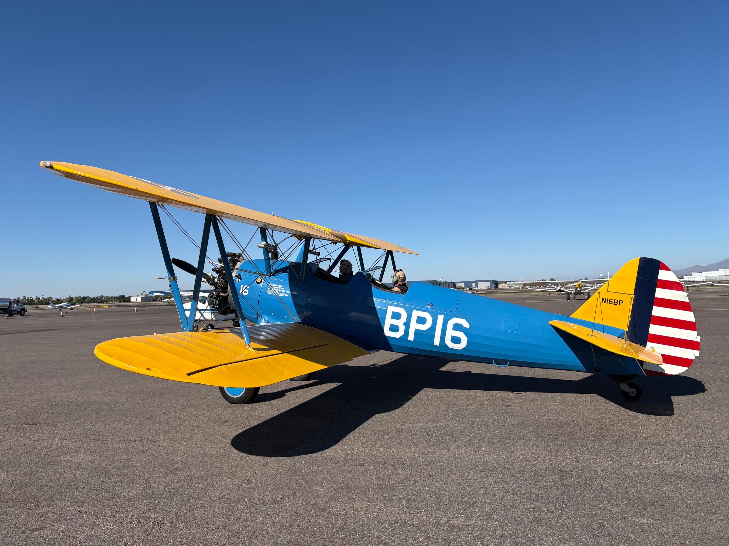 PT-17 Stearman in Falcon Field BFTS livery — number 16 — on the ramp