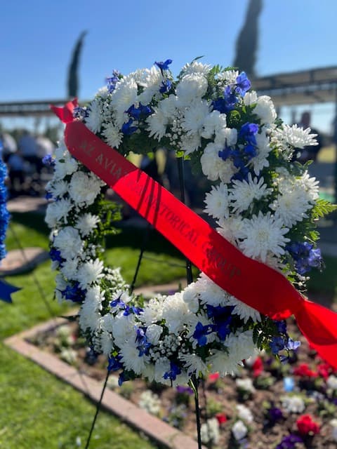 The AAHG memorial wreath of white and blue flowers with a red ribbon reading AZ Aviation Historical Group.