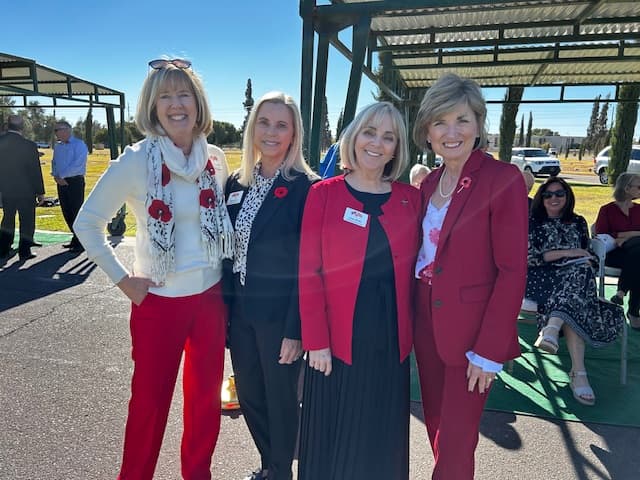 Four attendees in remembrance red wearing poppy pins.